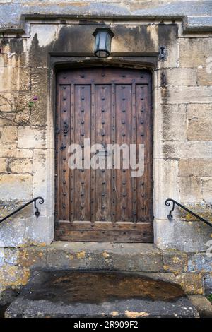 Alte Holztür mit Treppe in einem alten Steinhaus, Broadway, Cotswolds, Worcestershire, England, Vereinigtes Königreich Stockfoto