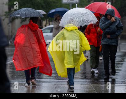 23. Juni 2023, Berlin: Touristen mit Regenschirmen und Regenponchos machen einen Spaziergang über die Museumsinsel im strömenden Regen. Foto: Monika Skolimowska/dpa Stockfoto