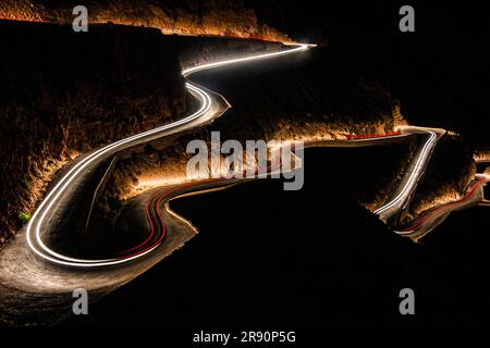 Die Nacht und die Schlangenstraße, die den Berg hinunterzieht. Eine Serpentine Straße, die die Rückseite des Berges zieht. "Gorges du Dades" Marokko. Stockfoto