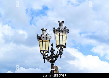 Schmiedeeiserne Laterne unter blauem Himmel mit weißen Wolken an der Plaza des Born in Ciutadella, Menorca Stockfoto