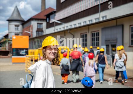 Portrait glückliche Touristin trägt gelbe Schutzhelm-Ausrüstung bei Rammelsberg UNESCO Mine Tour in kleiner Gruppe. Tourismus im Industriebergbau Stockfoto