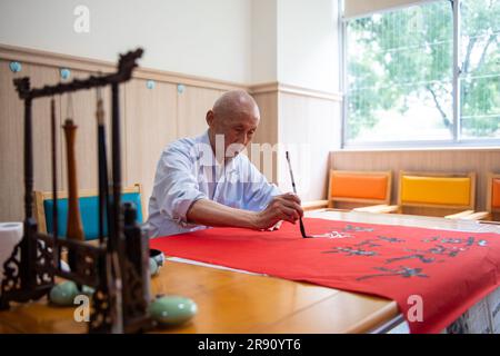 (230623) -- CHANGSHA, 23. Juni 2023 (Xinhua) -- Ein Senior Resident praktiziert Kalligraphie in einem Pflegeheim in Hanshou County in Changde City, Zentralchina Provinz Hunan, 20. Juni 2023. Die Stadt Changde hat ihre Anstrengungen zur Entwicklung eines Altenpflegesystems verstärkt, das hauptsächlich aus häuslichen, gemeinnützigen, institutionellen und medizinischen Betreuungseinrichtungen besteht. (Xinhua/Chen Sihan) Stockfoto