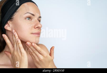 Weibliches Schönheitsmodell, das Kinesio-Klebebänder im Gesicht anbringt, Hautpflege, Anti-Falten. Stockfoto