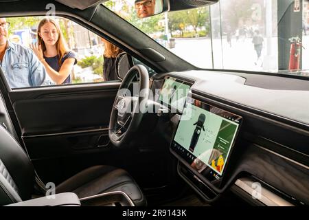 Automobil-Enthusiasten nehmen am Freitag, den 16. Juni 2023, an der Eröffnung eines Ausstellungsraums im Meatpacking District in New York Teil. Rivian hat sich im Meatpacking District mit anderen Herstellern von Luxus-Elektrofahrzeugen wie Tesla, Genesis und Lucid zusammengetan. (© Richard B. Levine) Stockfoto
