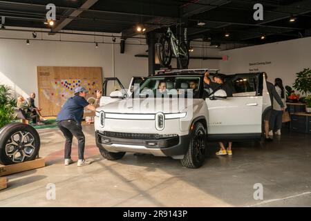 Automobil-Enthusiasten nehmen am Freitag, den 16. Juni 2023, an der Eröffnung eines Ausstellungsraums im Meatpacking District in New York Teil. Rivian hat sich im Meatpacking District mit anderen Herstellern von Luxus-Elektrofahrzeugen wie Tesla, Genesis und Lucid zusammengetan. (© Richard B. Levine) Stockfoto
