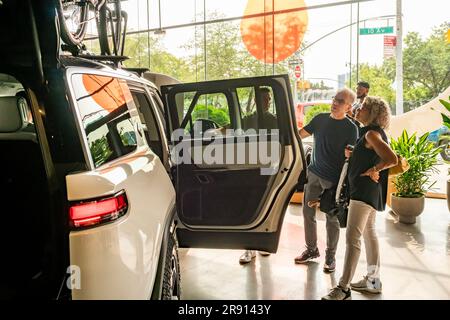 Automobil-Enthusiasten nehmen am Freitag, den 16. Juni 2023, an der Eröffnung eines Ausstellungsraums im Meatpacking District in New York Teil. Rivian hat sich im Meatpacking District mit anderen Herstellern von Luxus-Elektrofahrzeugen wie Tesla, Genesis und Lucid zusammengetan. (© Richard B. Levine) Stockfoto