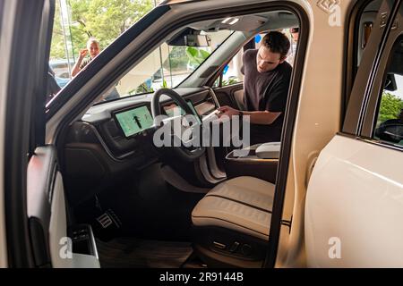 Automobil-Enthusiasten nehmen am Freitag, den 16. Juni 2023, an der Eröffnung eines Ausstellungsraums im Meatpacking District in New York Teil. Rivian hat sich im Meatpacking District mit anderen Herstellern von Luxus-Elektrofahrzeugen wie Tesla, Genesis und Lucid zusammengetan. (© Richard B. Levine) Stockfoto