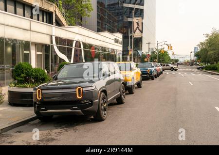 Automobil-Enthusiasten nehmen am Freitag, den 16. Juni 2023, an der Eröffnung eines Ausstellungsraums im Meatpacking District in New York Teil. Rivian hat sich im Meatpacking District mit anderen Herstellern von Luxus-Elektrofahrzeugen wie Tesla, Genesis und Lucid zusammengetan. (© Richard B. Levine) Stockfoto