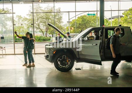 Automobil-Enthusiasten nehmen am Freitag, den 16. Juni 2023, an der Eröffnung eines Ausstellungsraums im Meatpacking District in New York Teil. Rivian hat sich im Meatpacking District mit anderen Herstellern von Luxus-Elektrofahrzeugen wie Tesla, Genesis und Lucid zusammengetan. (© Richard B. Levine) Stockfoto