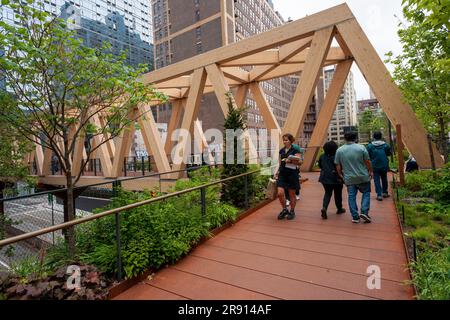 Besucher durchqueren den High Line-Moynihan Connector im Viertel Hudson Yards am Eröffnungstag, Donnerstag, den 22. Juni 2023. Die Holzbrücke und die dazugehörige Waldbrücke verbinden die High Line Extension mit dem Manhattan West plaza in Brookfield, so dass die Moynihan Train Hall fast verkehrsfrei zu Fuß erreichbar ist. (© Richard B. Levine) Stockfoto