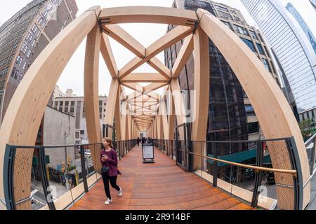 Besucher durchqueren den High Line-Moynihan Connector im Viertel Hudson Yards am Eröffnungstag, Donnerstag, den 22. Juni 2023. Die Holzbrücke und die dazugehörige Waldbrücke verbinden die High Line Extension mit dem Manhattan West plaza in Brookfield, so dass die Moynihan Train Hall fast verkehrsfrei zu Fuß erreichbar ist. (© Richard B. Levine) Stockfoto