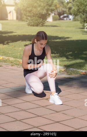 Die Sportlerin hat beim Laufen akute Schmerzen in ihrer Seite. Stockfoto