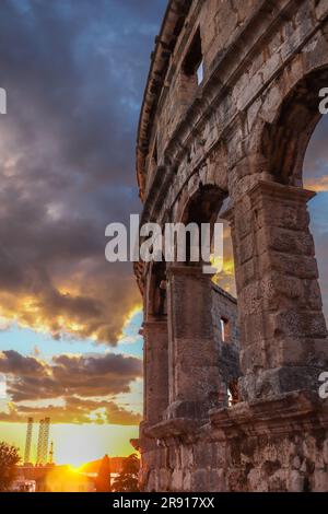 Vertikaler Blick auf die Pula Arena mit Sonnenuntergang im Sommer. Golden Hour Sky mit Wolken und römischem Amphitheater im istrischen Kroatien. Stockfoto