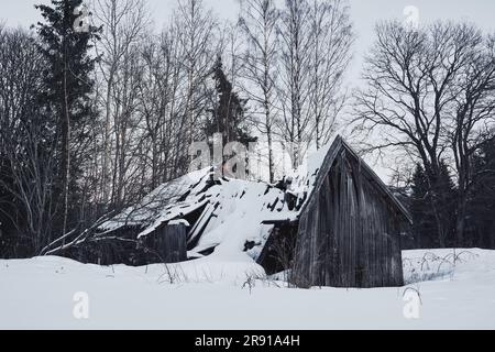 Ein alter, schneebedeckter Holzschuppen auf einem Berg in der Nähe von Toten und Lake Mjosa, Norwegen Stockfoto