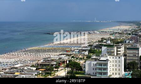 Panoramablick auf die Adriaküste und die Stadt Cervia-Milano Marittima mit ihrem Touristenhafen und vielen Sonnenschirmen am Strand. Stockfoto