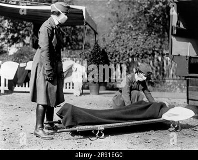 Washington, D.C.: 1918 zwei Rotkreuz-Krankenschwestern mit einer Person auf einer Trage während einer Demonstration in der Rotkreuz-Notarztstation während der Grippepandemie von 1918-1920. Stockfoto