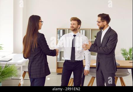 Boss schüttelt der jungen Frau die Hand und gratuliert der Mitarbeiterin zur Beförderung Stockfoto