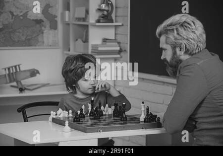 Lehrer und Kind. Spiele und Aktivitäten für Kinder. Lehrer und Kind. Männerlehrer spielt Schach mit Vorschulkind. Vater und Sohn Stockfoto