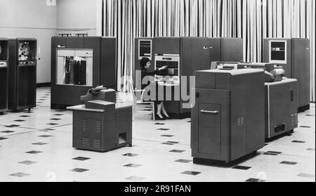 New York, New York, 1954 Frau, die eine neue IBM 650 Magnettrommel-Datenverarbeitungsmaschine im Büro verwendet. Sie arbeitet im "elektronischen Gehirn", während die IBM RAM-Einheit links einen 6.000.000-stelligen Speicher hat. Stockfoto