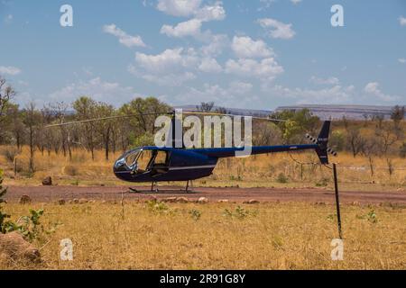 Ein kleiner Hubschrauber ruht auf dem Boden in einem Anwesen im Outback in Westaustralien Stockfoto