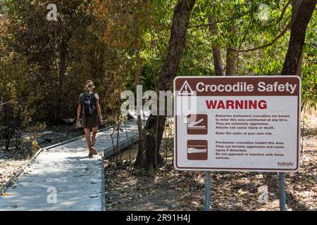 Eine Frau geht an einem Krokodil-Warnschild im Kakadu-Nationalpark in Australien vorbei Stockfoto