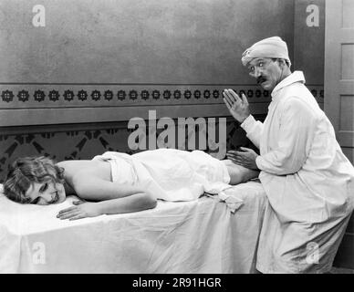 Los Angeles, Kalifornien: ca. 1926 A Standbild aus einem Hollywood Stummfilm mit einer hübschen Frau, die eine Massage bekommt. Stockfoto