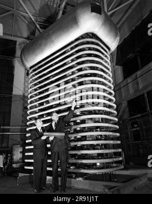 Schenectady, New York, 12. Februar 1959 James Young (r), General Manager des Engineering Laboratory von General Electric, mit dem neuen Elektronenbeschleuniger von GE, der dazu beitragen wird, die Auswirkungen von Strahlung auf Materialien in einem Langstreckenprogramm zu untersuchen. Stockfoto