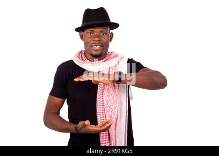 Lächelnder junger Mann mit Hut und Schal in Übergröße und Übergröße mit beiden Händen. Stockfoto