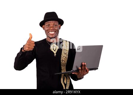 Gut gekleideter junger Mann mit Laptop und lächelndem Daumen nach oben. Stockfoto