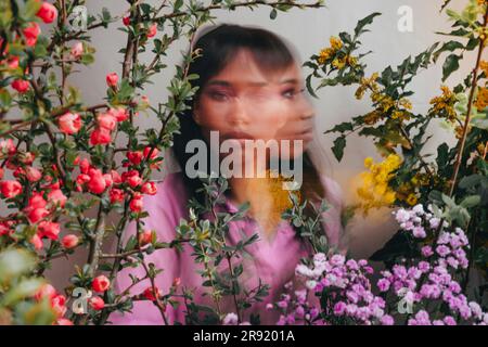 Mehrfachbild einer jungen Frau inmitten bunter Blumen Stockfoto