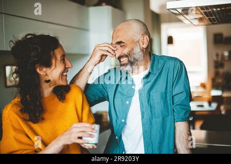 Ein glücklicher Mann mit einer Frau, die zu Hause Kaffee trinkt Stockfoto