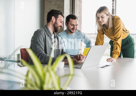 Lächelnde Geschäftskollegen, die im Büro zusammenarbeiten Stockfoto