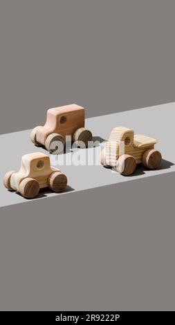 Spielzeugautos aus Holz auf grauem Hintergrund Stockfoto