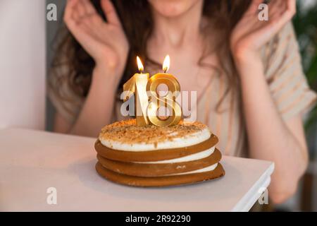Geburtstagskuchen mit brennender Kerze Nummer 18 zu Hause Stockfoto