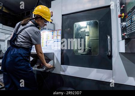 Wartungstechniker, der in einem modernen Werk an der CNC-Maschine arbeitet Stockfoto