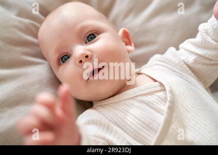 Süßes kleines Mädchen, das zu Hause im Kinderbett liegt Stockfoto