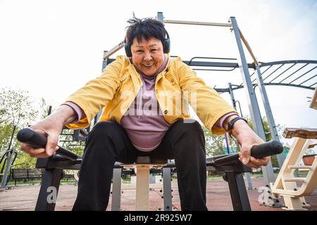 Lächelnde Seniorin, die im Park trainiert Stockfoto