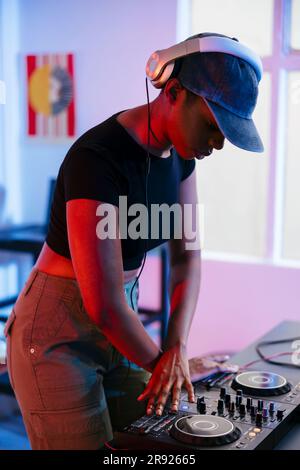 Junger DJ, der zu Hause Musik über den Soundmixer macht Stockfoto