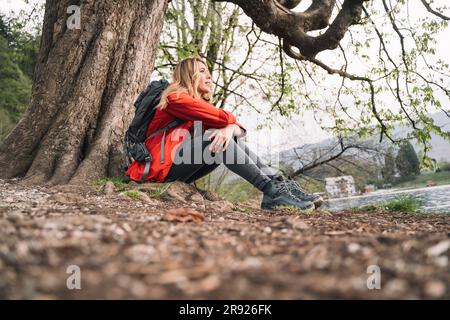 Wanderer ruhen sich in der Nähe eines Baumes im Wald aus Stockfoto