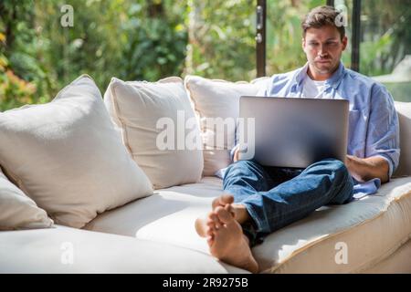 Professioneller Freiberufler, der zu Hause mit einem Notebook arbeitet Stockfoto