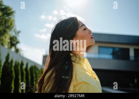 Frau mit geschlossenen Augen im Garten Stockfoto