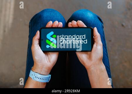 In dieser Abbildung wird das Standard Chartered Logo auf dem Bildschirm eines Smartphones angezeigt. Stockfoto