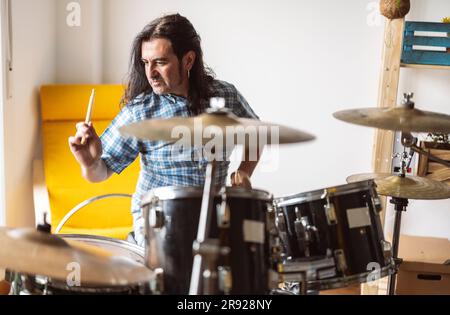 Musiker, der zu Hause Trommel spielt Stockfoto