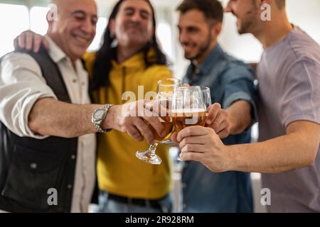 Glückliche Freunde, die zusammen Bier toasten Stockfoto