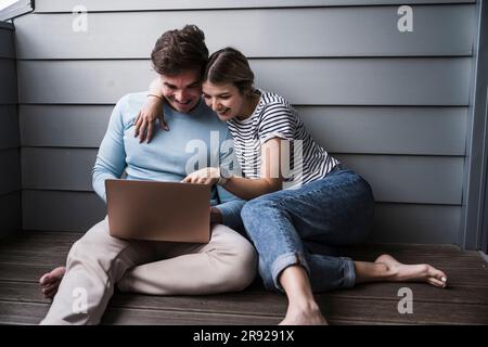 Glückliches junges Paar mit Laptop zusammen Stockfoto