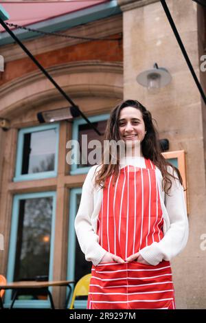 Lächelnder Florist mit Händen in Schürzentaschen Stockfoto
