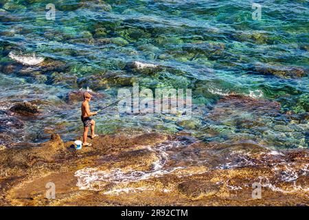 FRANKREICH. HERAULT (34) CAP D'AGDE. FISCHER AM FUSSE DER KLIPPE BEI CAP D'AGDE Stockfoto