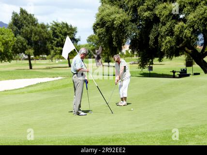 Mann mit Flagge, alte Frau oder Golfer auf dem Golfplatz für ein Vögelchen, Schlaganfall oder Bewegung im Ruhestand. Älteres Paar, reifer oder ernster Spieler Stockfoto