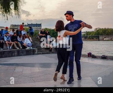 05-14-2023 Paris, Frankreich "Tango in Paris" : Tango am Ufer der seine im fantastischen Mai. Tanzpaare. Wasser und seine dahinter. Stockfoto