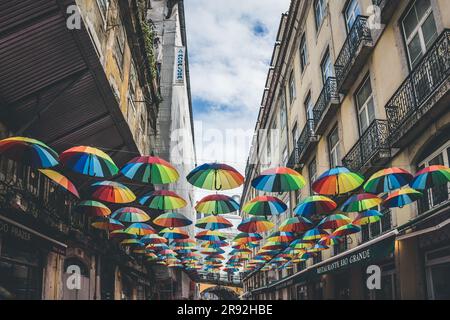 Lissabon, Portugal - 8. März 2023: Farbenfrohe Sonnenschirme, die auf der Straße in Lissabon, Portugal, schweben Stockfoto